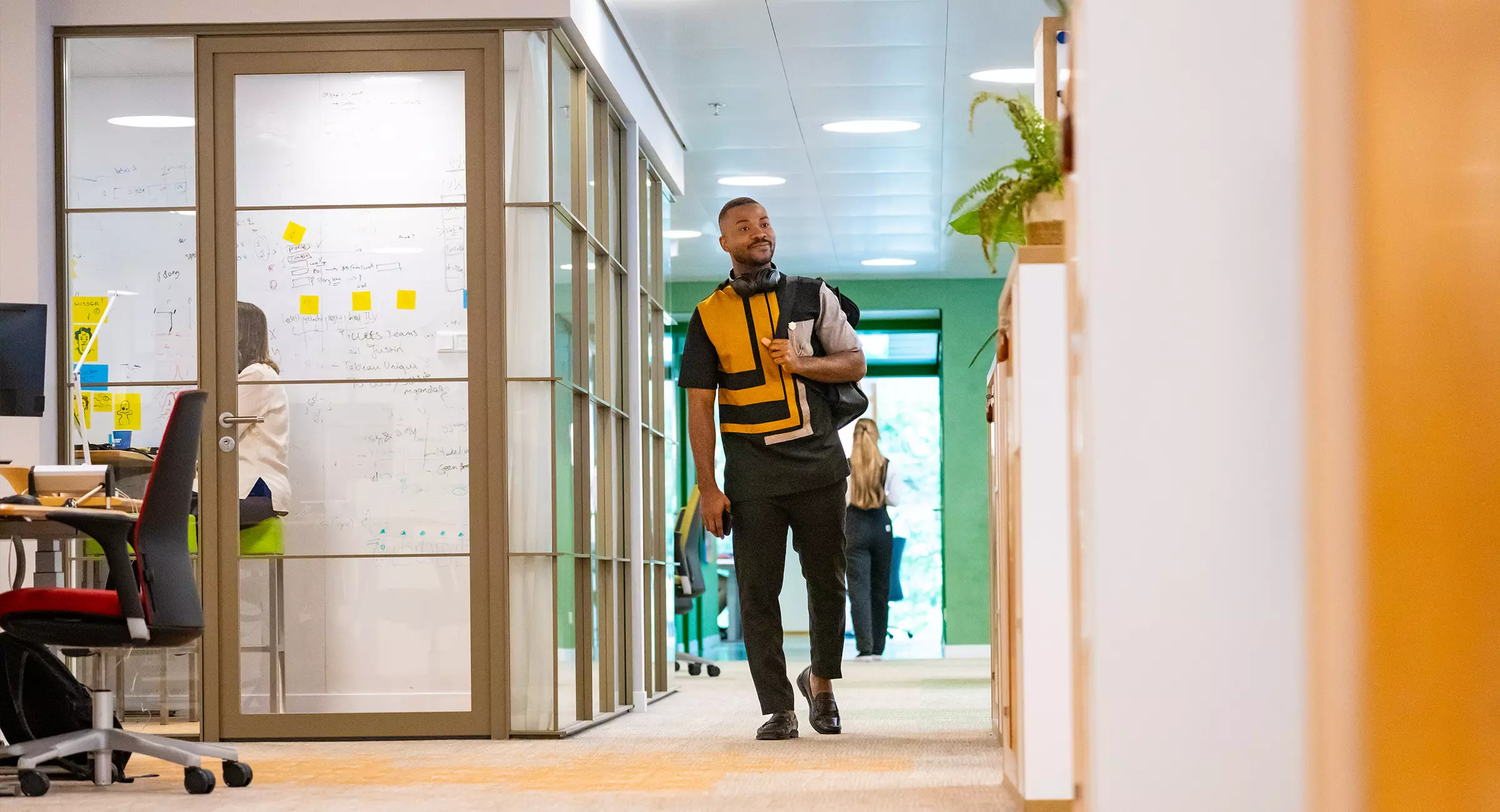 Drie collega's overleggen lachend op het kantoor van de Postcode Loterij.