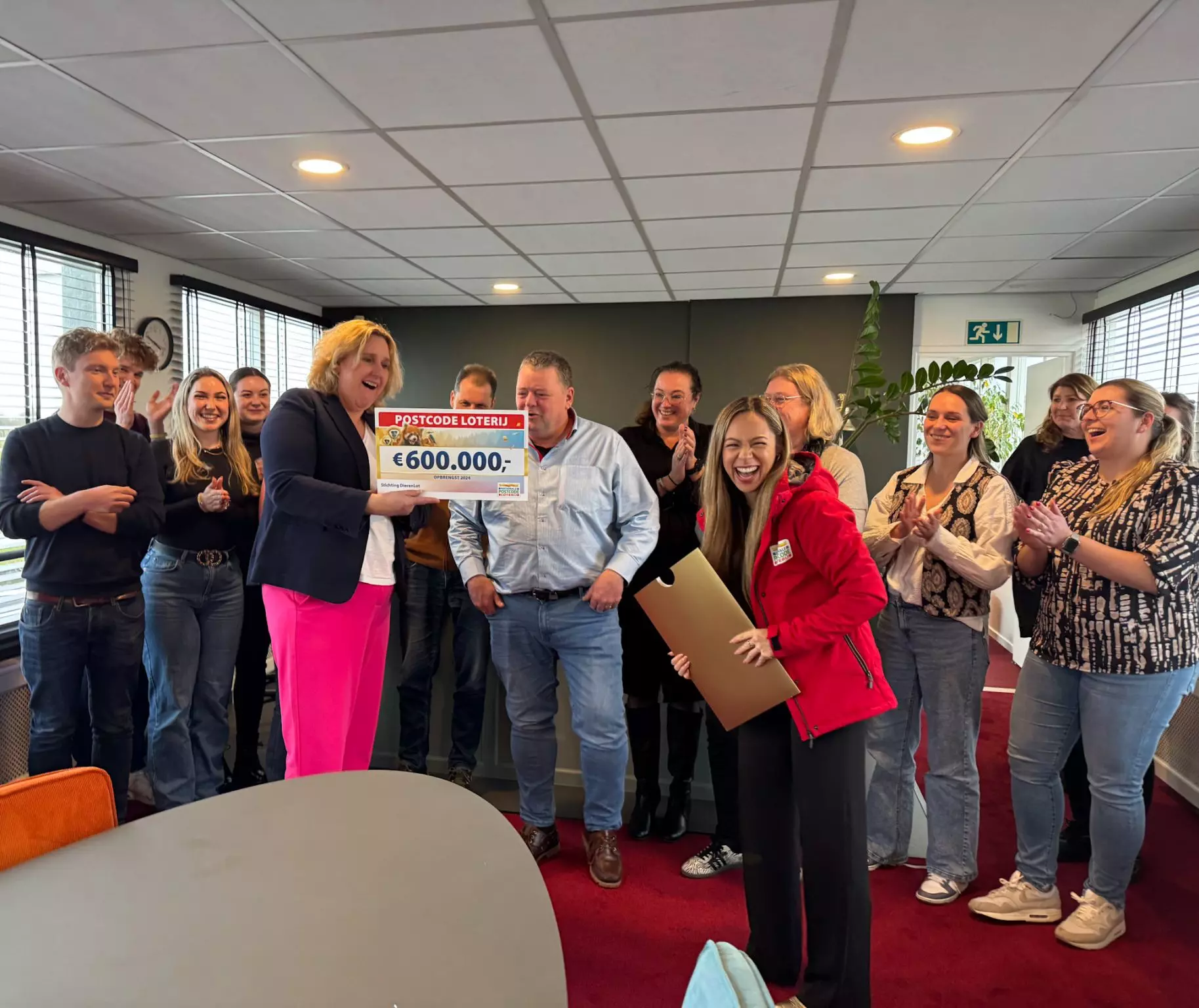 Collega Rowan Lekatompessij rijkt een cheque van 600.000 euro uit aan Stichting DierenLot.